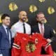 Nick Foligno (center) smiles with Kyle Davidson (left) and Danny Wirtz (right). Foligno was named the 35th captain of the Chicago Blackhawks.