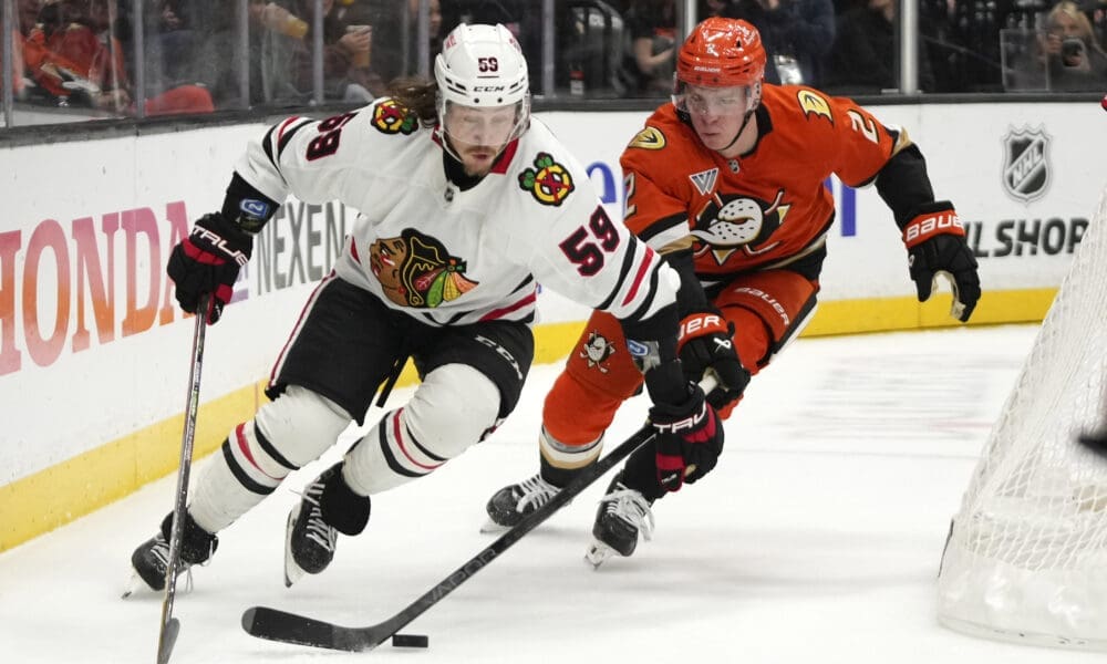 Chicago Blackhawks left wing Tyler Bertuzzi, left, takes the puck as Anaheim Ducks defenseman Jackson LaCombe reaches in during the second period of an NHL hockey game, Sunday, Nov. 3, 2024, in Anaheim, Calif. (AP Photo/Mark J. Terrill)