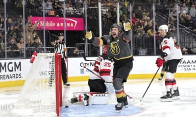 Vegas Golden Knights right wing Mark Stone, center, celebrates after scoring against New Jersey Devils goaltender Jacob Markstrom (25) during the third period of an NHL hockey game, Sunday, March 2, 2025, in Las Vegas. New Jersey Devils defenseman Brenden Dillon (5) looks on at right. (Steve Marcus/Las Vegas Sun via AP)
