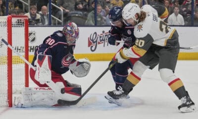 Vegas Golden Knights left wing Brandon Saad (20) shoots on Columbus Blue Jackets goaltender Elvis Merzlikins (90) next to defenseman Ivan Provorov (9) in the first period of an NHL hockey game Thursday, March 13, 2025, in Columbus, Ohio. (AP Photo/Sue Ogrocki)