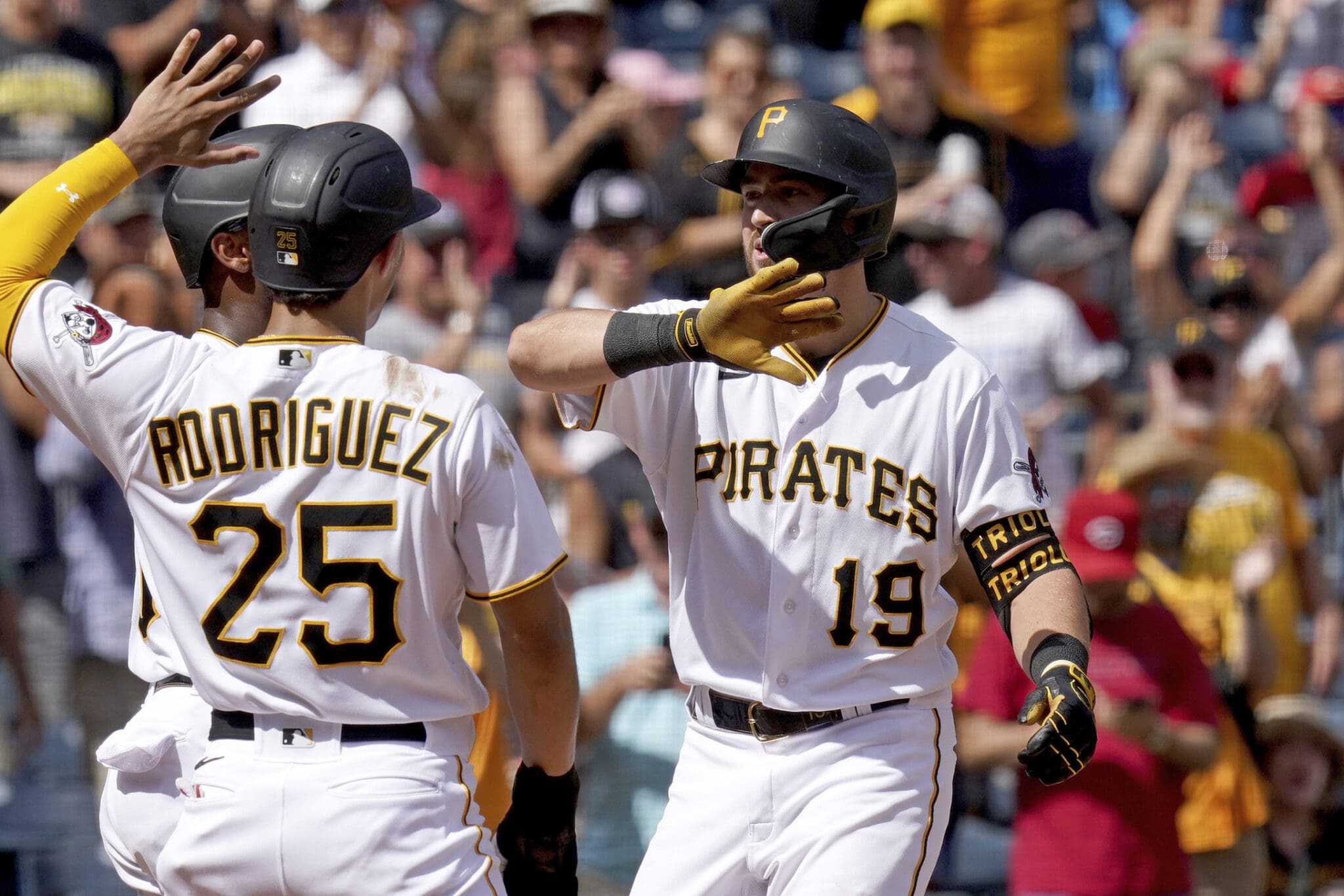 Pittsburgh Pirates' Jared Triolo (19) celebrates after his three-run home run against the Cincinnati Reds with Liover Peguero, back left, and Endy Rodriguez (25) during the seventh inning in the first baseball game of a doubleheader in Pittsburgh, Sunday, Aug. 13, 2023. (AP Photo/Matt Freed)