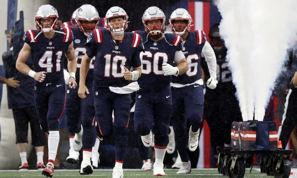 New England Patriots are led out by captains Mac Jones and David Andrews to take the field for their Week 1 game against the Philadelphia Eagles.