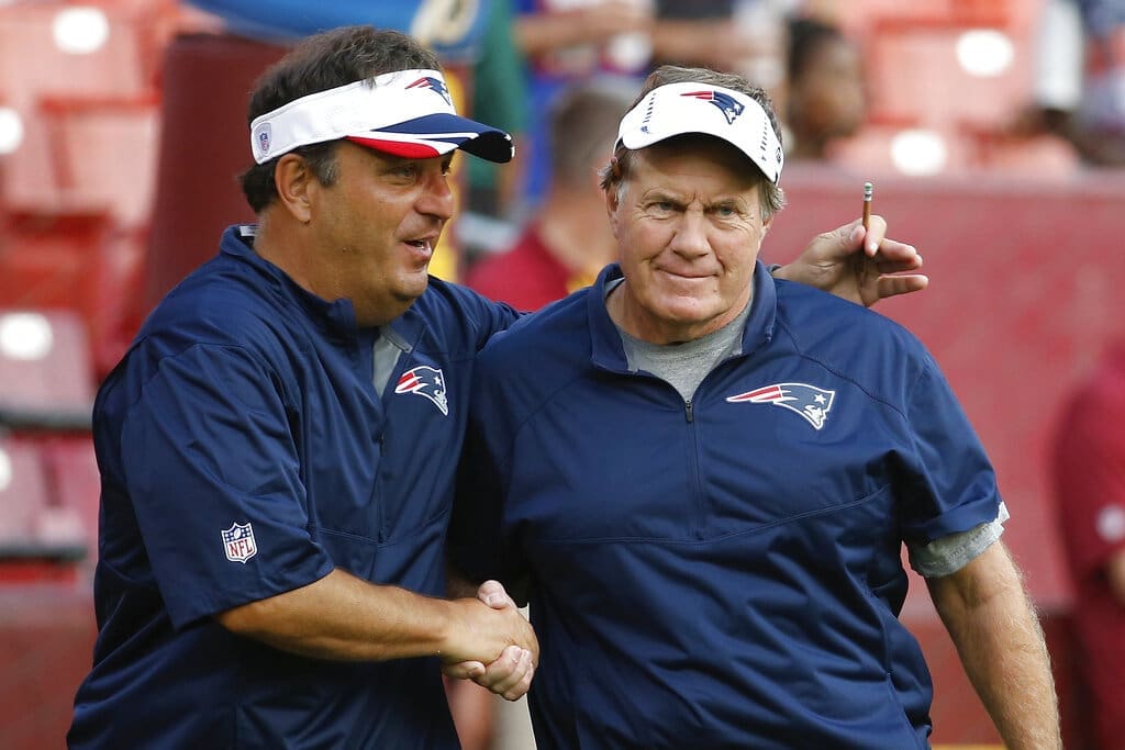 New England Patriots assistant coach Michael Lombardi. left, shakes hands with oach Bill Belichick before an NFL football preseason game against the Washington Redskins in Landover, Md., Thursday, Aug. 7, 2014. (AP Photo/Alex Brandon)