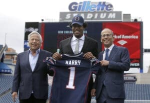 New England Patriots owner Robert Kraft, left, and his son, team president Jonathan Kraft, right, pose with first-round draft pick wide receiver N'Keal Harry, center, while introducing Harry at an NFL football news conference, Thursday, May 9, 2019, at Gillette Stadium, in Foxborough, Mass. (AP Photo/Steven Senne)