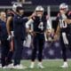 Patriots offensive coordinator Bill O'Brien talks to quarterbacks Mac Jones and Bailey Zappe while Bill Belichick looks on.