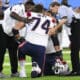 New England Patriots offensive tackle Riley Reiff (74) is tended to after being hurt during an NFL preseason football game against the Tennessee Titans Saturday, Aug. 26, 2023, in Nashville, Tenn. (AP Photo/John Amis)