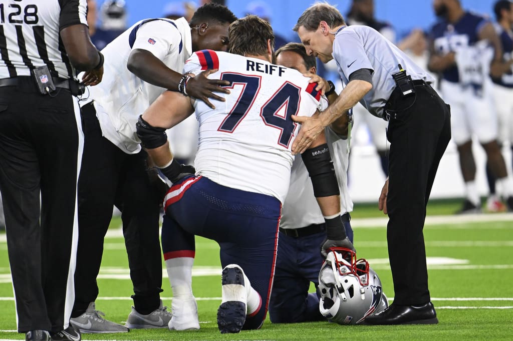 New England Patriots offensive tackle Riley Reiff (74) is tended to after being hurt during an NFL preseason football game against the Tennessee Titans Saturday, Aug. 26, 2023, in Nashville, Tenn. (AP Photo/John Amis)