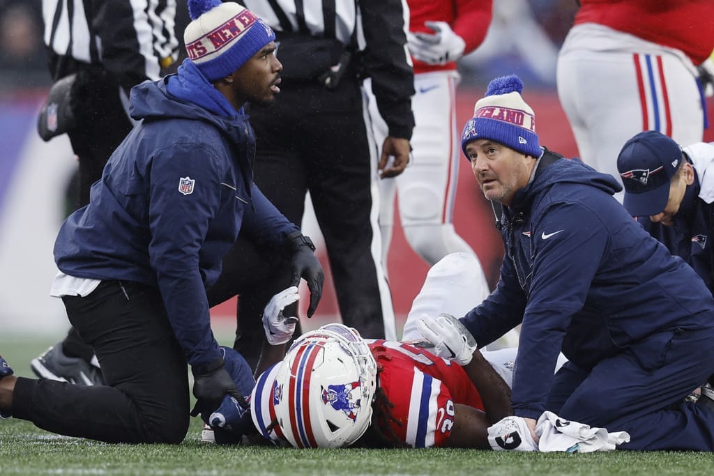 New England Patriots running back Rhamondre Stevenson is attended to by medical staff during the first half of an NFL football game against the Los Angeles Chargers, Sunday, Dec. 3, 2023, in Foxborough, Mass. (AP Photo/Michael Dwyer)