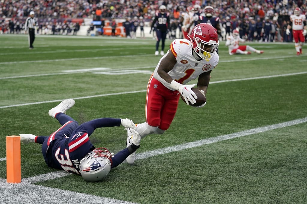 Kansas City Chiefs running back Jerick McKinnon (1) enters the end zone for a touchdown as New England Patriots linebacker Marte Mapu (30) tries to defend during the first half of an NFL football game, Sunday, Dec. 17, 2023, in Foxborough, Mass. (AP Photo/Charles Krupa)
