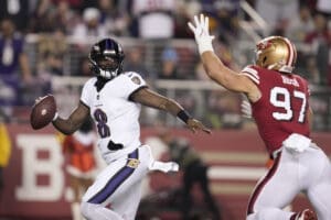 Baltimore Ravens quarterback Lamar Jackson (8) scrambles from San Francisco 49ers defensive end Nick Bosa (97) during the first half of an NFL football game in Santa Clara, Calif., Monday, Dec. 25, 2023. Baltimore took over the top spot in this week's NFL Power Rankings (AP Photo/Godofredo A. Vásquez)