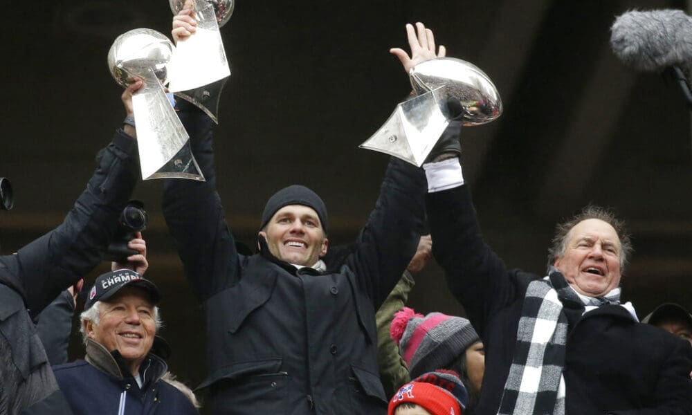 FILE - In this Feb. 7, 2017, file photo, New England Patriots quarterback Tom Brady holds up Super Bowl trophies along with head coach Bill Belichick, right, and team owner Robert Kraft, left, during a rally in Boston to celebrate the win over the Atlanta Falcons in the NFL Super Bowl 51 football game in Houston. Tom Brady is an NFL free agent for the first time in his career. The 42-year-old quarterback with six Super Bowl rings said Tuesday morning, March 17, 2020, that he is leaving the New England Patriots. The Patriots Dynasty won six Super Bowls. (AP Photo/Elise Amendola, File)
