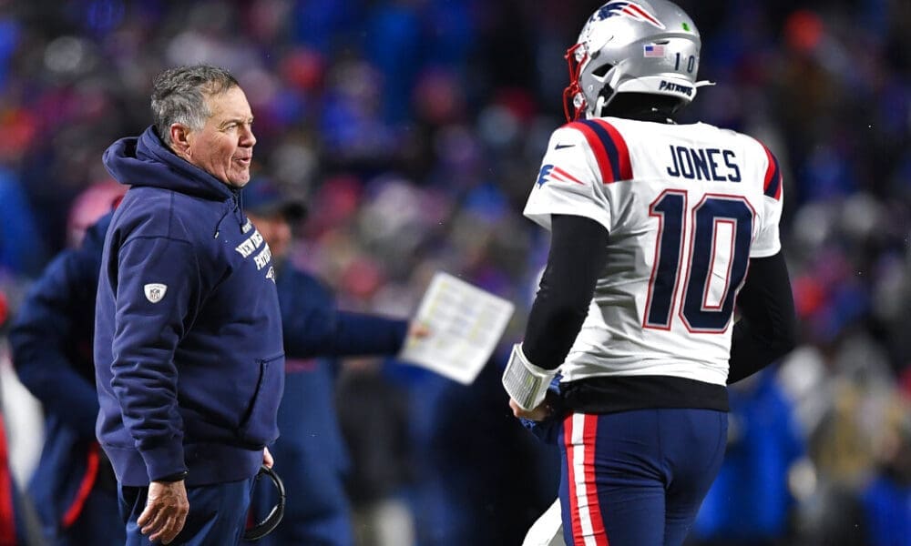 New England Patriots head coach Bill Belichick, left, talks to quarterback Mac Jones during the second half of an NFL football game against the Buffalo Bills in Orchard Park, N.Y., Monday, Dec. 6, 2021. (AP Photo/Adrian Kraus)