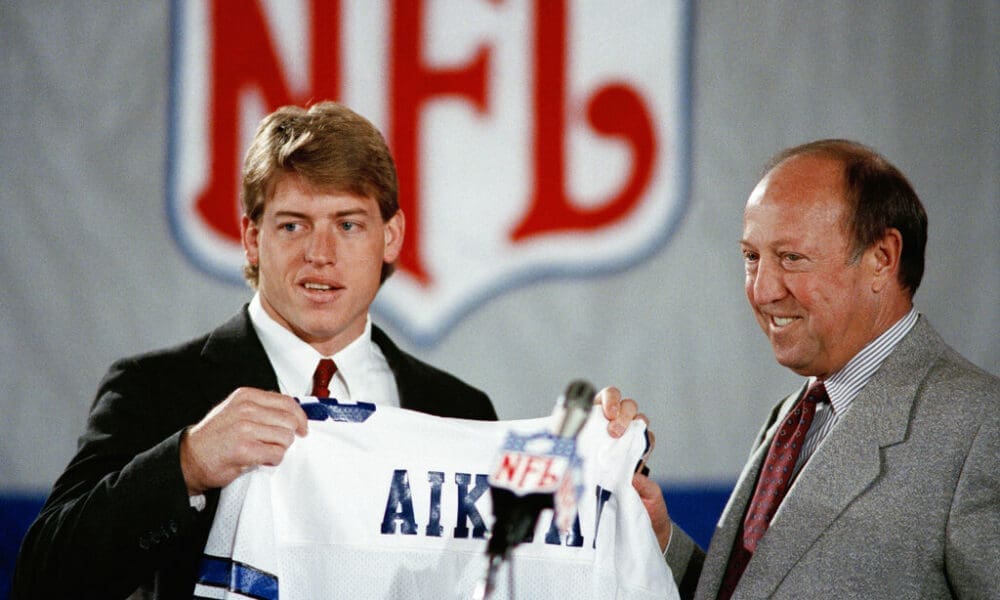 Pete Rozelle, NFL commissioner, right, began the 54th annual draft of collegiate talent. His final draft, by announcing the selection of UCLA quarterback Troy Aikman left, as the first pick of the NFL Draft by the Dallas Cowboys on Sunday, April 23, 1989 in New York. Aikman already has signed a six-year, $11.2 million contract wih the Cowboys.(AP Photo/Mark Lennihan)