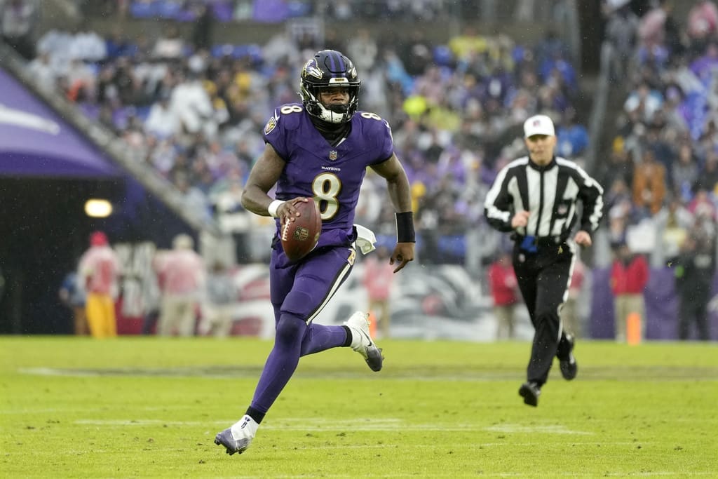 Baltimore Ravens quarterback Lamar Jackson runs with the ball against the Los Angeles Rams during the second half of an NFL football game Sunday, Dec. 10, 2023, in Baltimore. The Ravens won the NFL game 37-31 in overtime. (AP Photo/Alex Brandon)