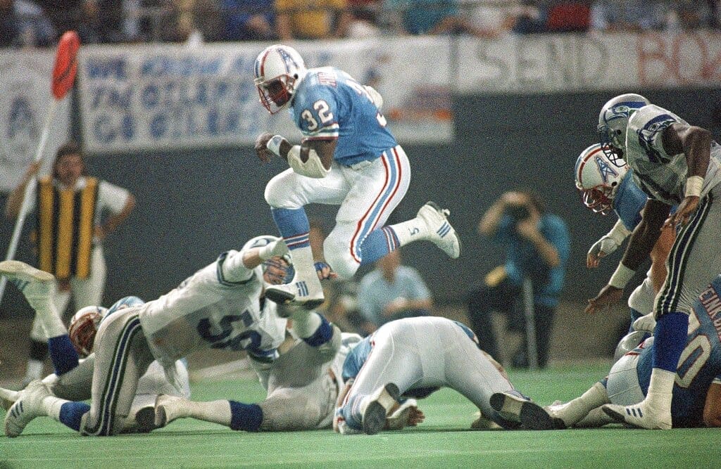 Houston Oilers fullback Alonzo Highsmith (32) goes jumping over fallen players in the third quarter of the NFL playoff game at Houston, Texas., Sunday, Jan. 3, 1988. Highsmith was hurt on the play after picking up six yards. (AP Photo/DGB)