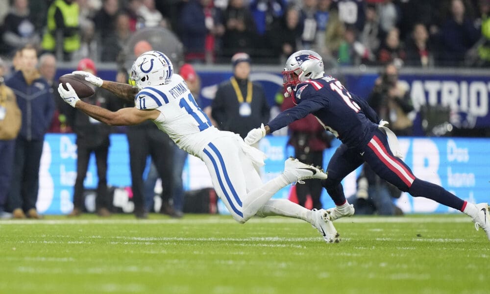 Indianapolis Colts wide receiver Michael Pittman Jr. (11) reaches out to bring in a catch over New England Patriots defensive back Jack Jones (13) during an NFL football game at Deutsche Bank Park Stadium in Frankfurt, Germany, Sunday, Nov. 12, 2023. (AP Photo/Doug Benc)