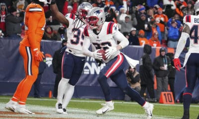 New England Patriots safety Cody Davis (22) scores a touchdown against the Denver Broncos of an NFL football game Sunday December 24, 2023, in Denver. (AP Photo/Bart Young)