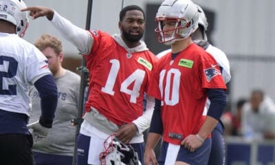 New England Patriots quarterback Jacoby Brissett (14) speaks with quarterback Drake Maye (10) during an NFL football practice, Monday, May 20, 2024, in Foxborough, Mass. (AP Photo/Steven Senne)