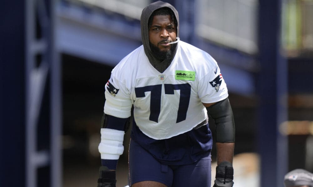 New England Patriots offensive tackle Chukwuma Okorafor (77) steps on the field for an NFL football practice, Wednesday, May 29, 2024, in Foxborough, Mass. (AP Photo/Steven Senne)