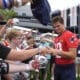 New England Patriots quarterback Drake Maye (10), center right, signs autographs for fans following an NFL football training camp, Wednesday, July 24, 2024, in Foxborough, Mass. (AP Photo/Steven Senne)
