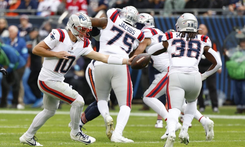 New England Patriots quarterback Drake Maye (10) passes the ball to running back Rhamondre Stevenson (38) during the first half of an NFL football game against the Chicago Bears, Sunday, Nov. 10, 2024, in Chicago. The Patriots defeated the Bears 19-3. (AP Photo/Kamil Krzaczynski)