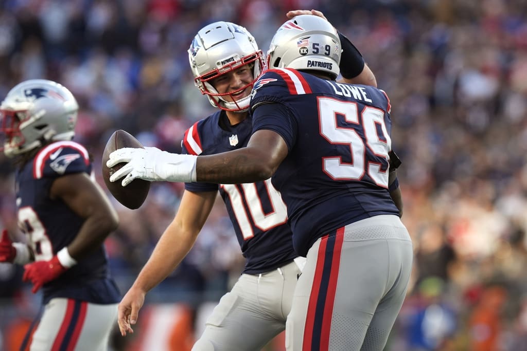 New England Patriots offensive tackle Vederian Lowe (59) is congratulated by quarterback Drake Maye after scoring a touchdown against the Los Angeles Rams during the second half of an NFL football game, Sunday, Nov. 17, 2024, in Foxborough, Mass. (AP Photo/Michael Dwyer)