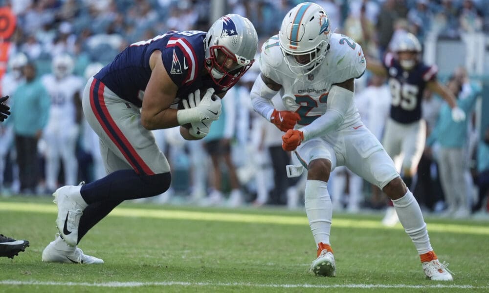 New England Patriots tight end Austin Hooper (81) runs for a touchdown as Miami Dolphins safety Jordan Poyer (21) defends during the second half of an NFL football game, Sunday, Nov. 24, 2024, in Miami Gardens, Fla. (AP Photo/Lynne Sladky)