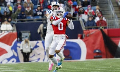 New England Patriots cornerback Christian Gonzalez (0) intercepts a pass intended for Indianapolis Colts wide receiver Alec Pierce (14) during the second half of an NFL football game, Sunday, Dec. 1, 2024, in Foxborough, Mass. The Indianapolis Colts won 25-24. (AP Photo/Greg M. Cooper)