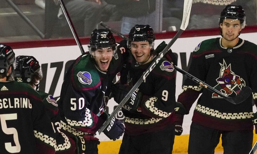 Arizona Coyotes' Sean Duran (50) and Clayton Keller (9) celebrate a power play open-net goal against the Pittsburgh Penguins' during the third period of an NHL hockey game Monday, Jan. 22, 2024, in Tempe, Ariz. (AP Photo/Darryl Webb)