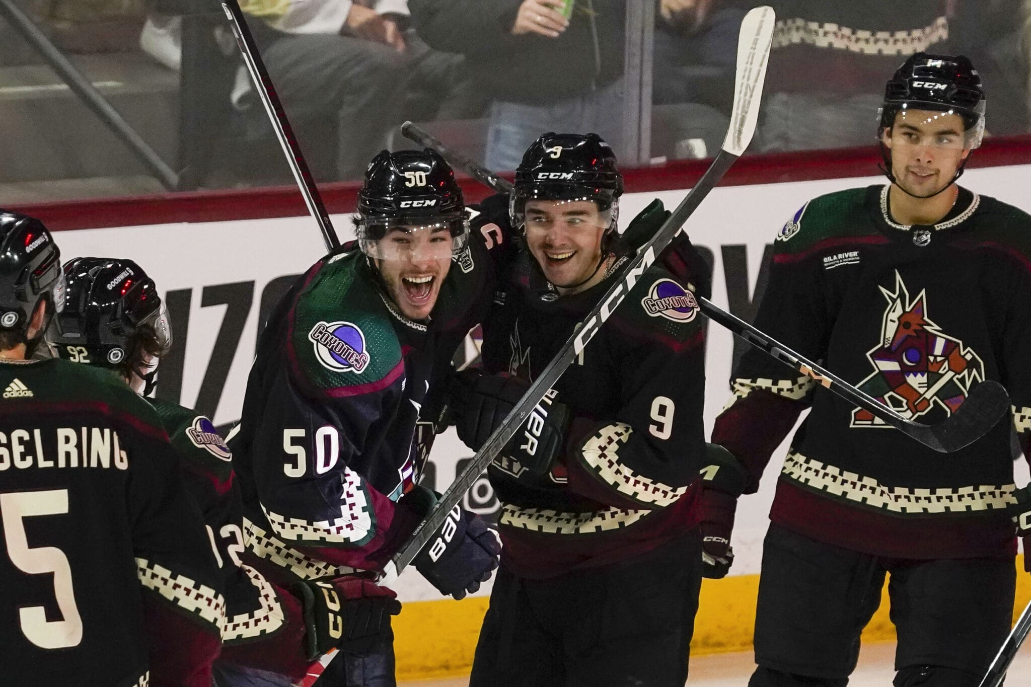 Arizona Coyotes' Sean Duran (50) and Clayton Keller (9) celebrate a power play open-net goal against the Pittsburgh Penguins' during the third period of an NHL hockey game Monday, Jan. 22, 2024, in Tempe, Ariz. (AP Photo/Darryl Webb)